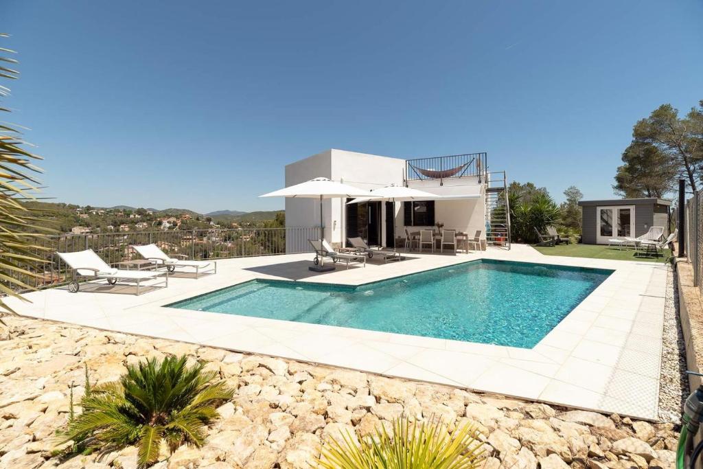 a villa with a swimming pool and a house at Luxury Sitges Hills Villa in Olivella