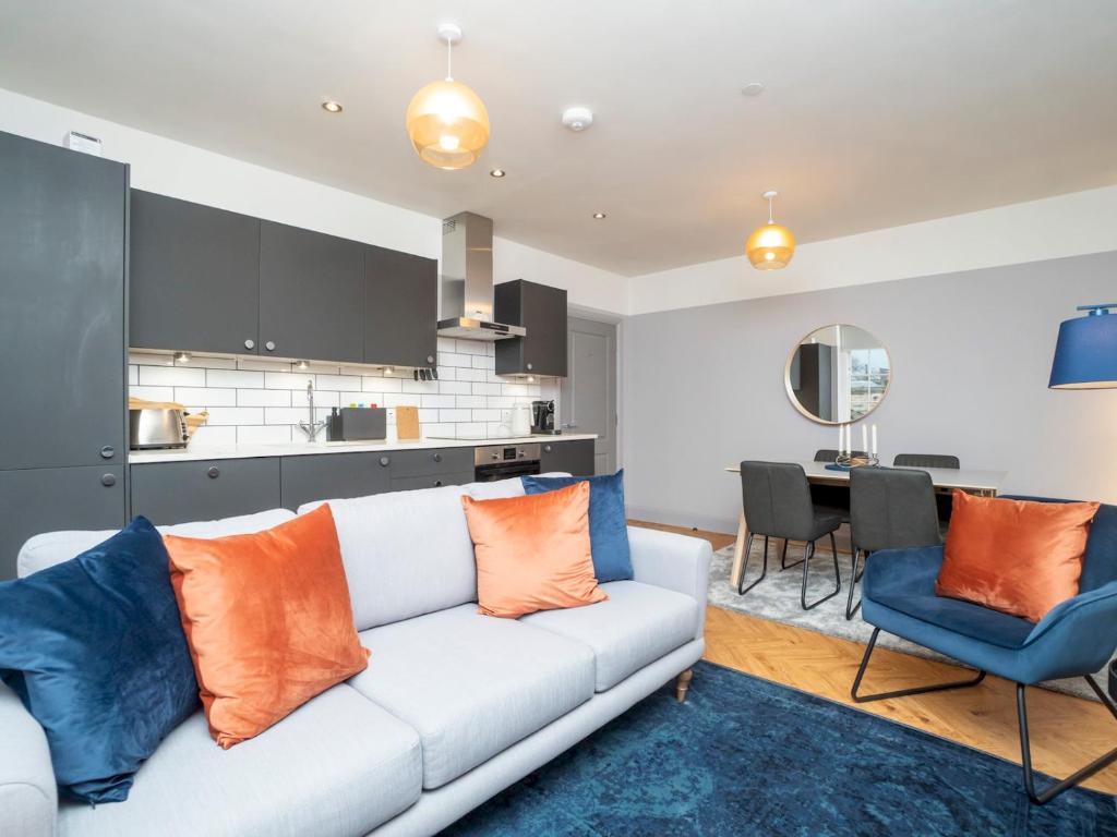 a living room with a white couch with orange and blue pillows at Pass the Keys Stunning 2 bed retreat in the heart of Bath in Bath