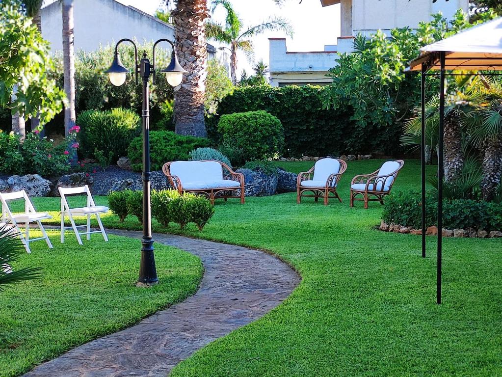 een groep stoelen en een lichtpaal in een tuin bij Casa Vacanze ANTICO CASALE in Marsala