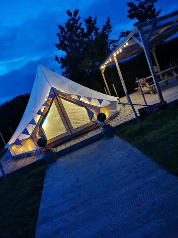 a tent is set up on a deck at night at Carrowmena School House & Glamping in Limavady