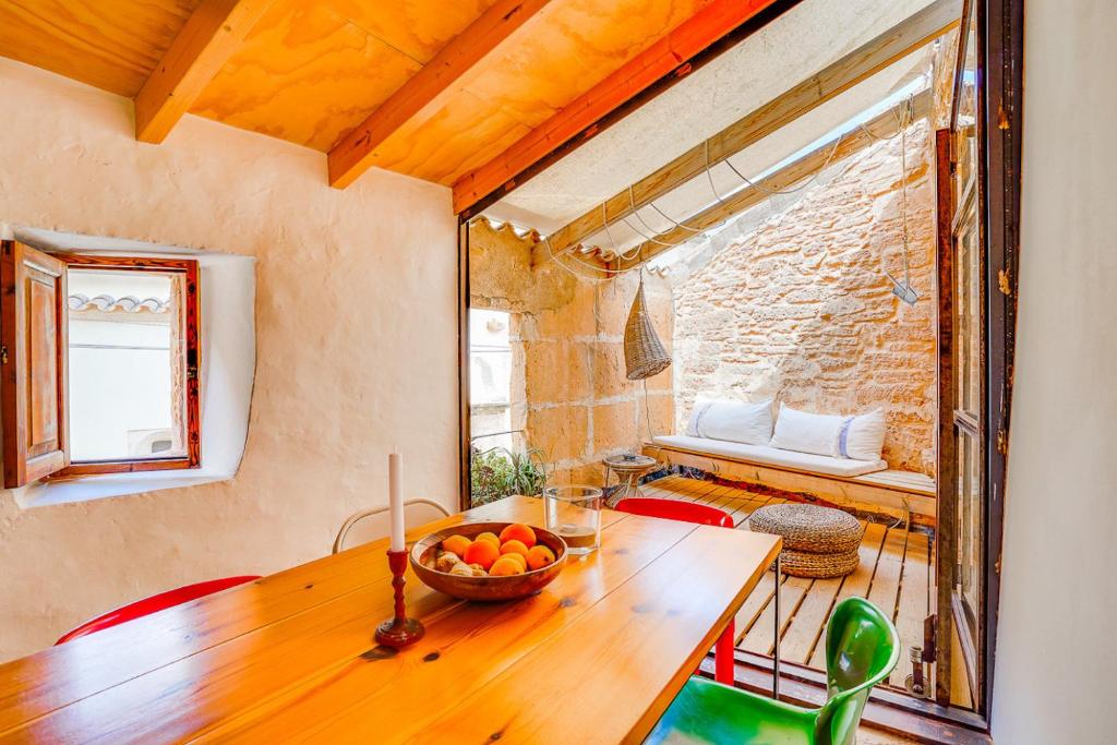 a dining room with a wooden table with a bowl of fruit at Ses Salines Terrace Home in Ses Salines