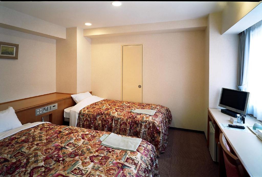 Postel nebo postele na pokoji v ubytování Kochi Ryoma Hotel
