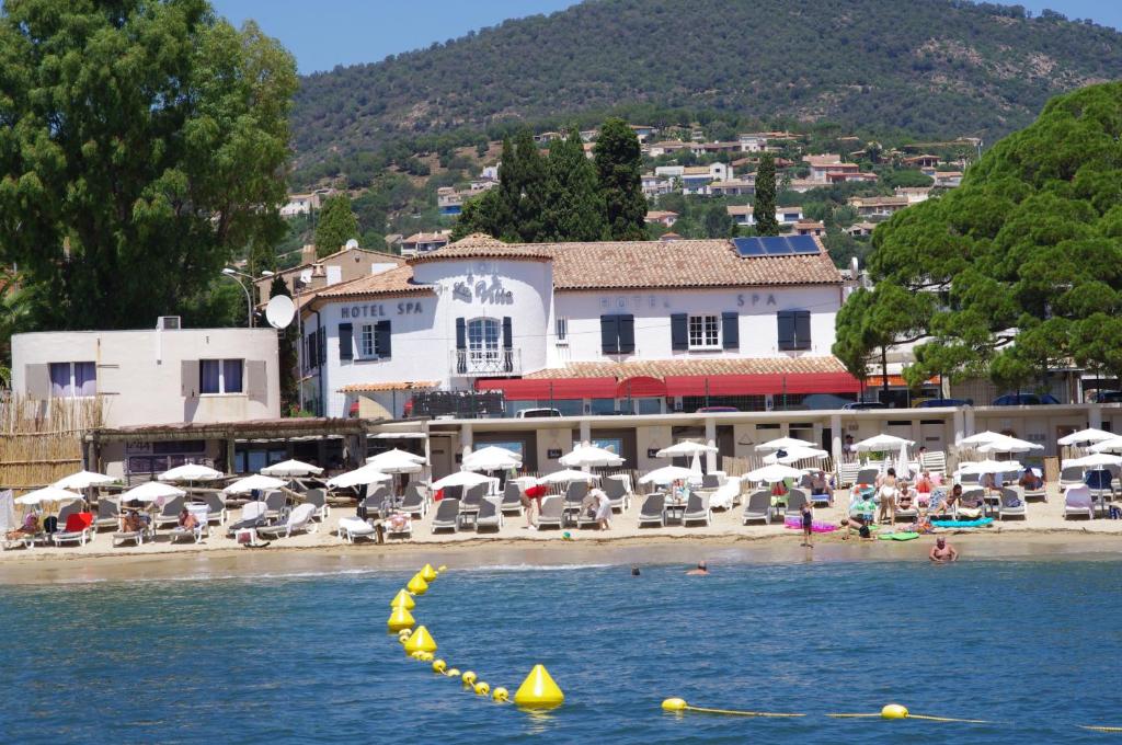 - une plage avec des parasols et des personnes sur la plage dans l'établissement Hôtel & Spa La Villa, à Sainte-Maxime