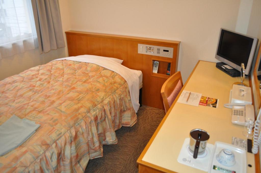 Postel nebo postele na pokoji v ubytování Kochi Ryoma Hotel