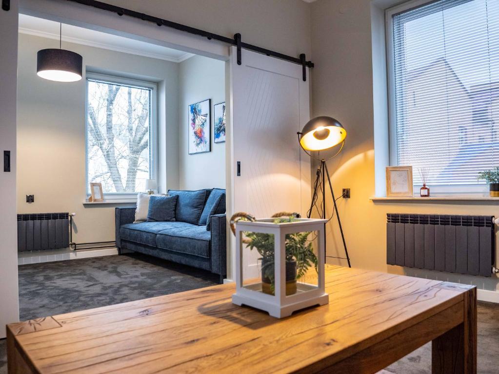 Una sala de estar con un sofá azul y una mesa. en Stylove Apartamenty, en Ustrzyki Dolne