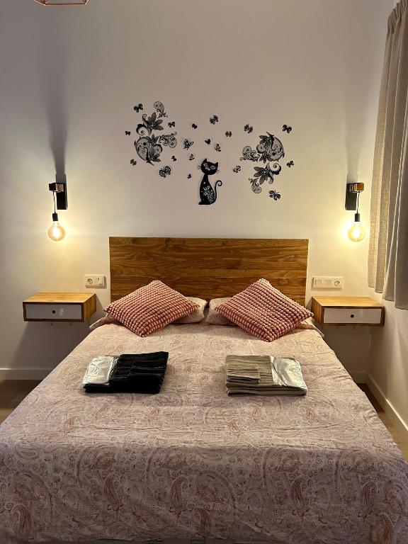 een slaapkamer met een groot bed met twee boeken erop bij Coqueto apartamento céntrico con piscina in Córdoba