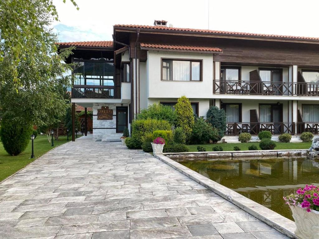 a house with a pond in front of it at Комплекс Белите скали in Gaytaninovo