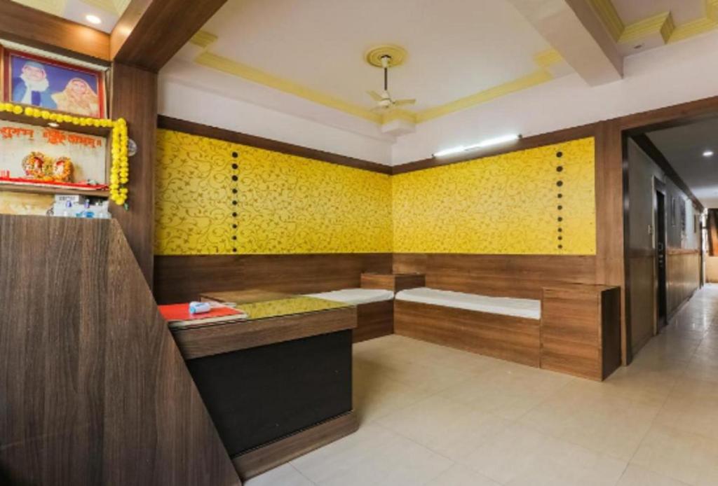 baño con paredes amarillas y pared de acento amarillo en Hotel Aditya Palace By WB Inn, en Kānpur