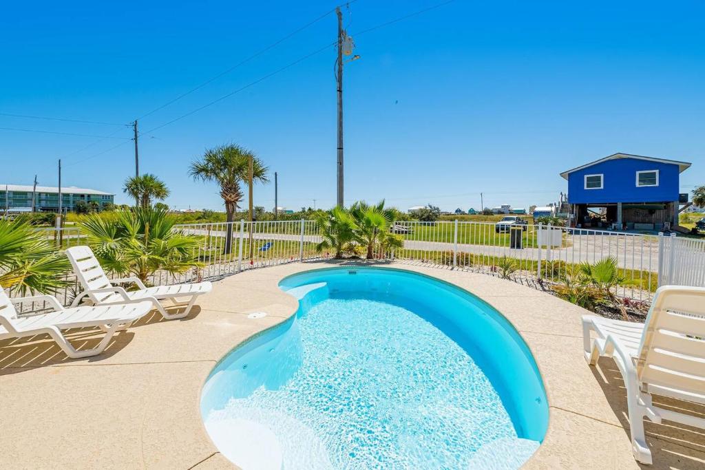 einen Pool mit zwei Gartenstühlen und einem Pool in der Unterkunft Bay Dreamin - Gulf Shores,Al in Gulf Shores