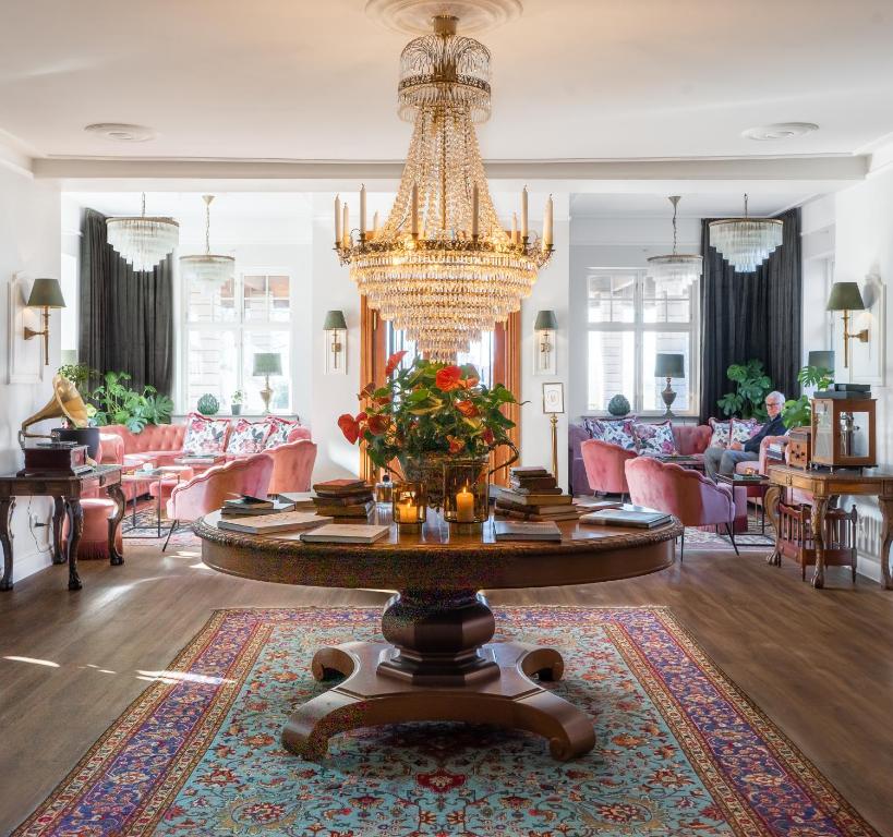 a large living room with a chandelier and a table at Villa Brunnby in Mölle