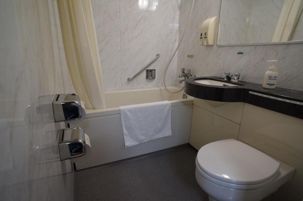 a small bathroom with a toilet and a sink at Ryokan Katsutaro in Tokyo