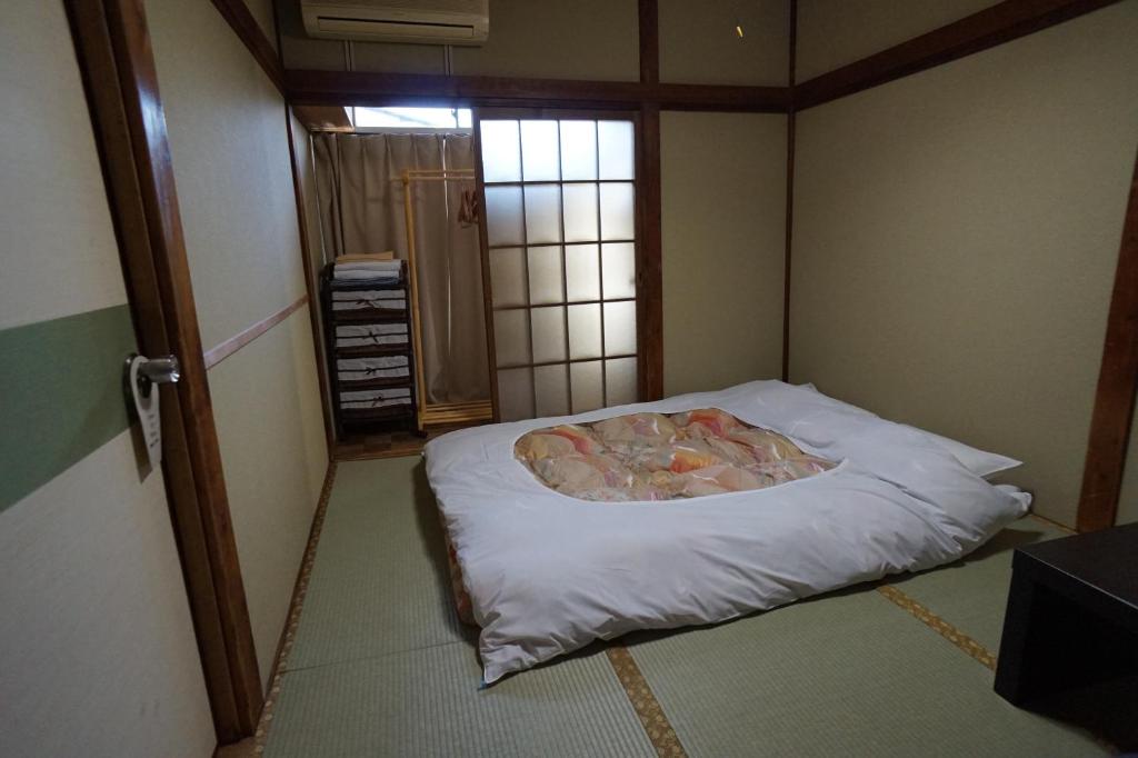 a small room with a bed in the corner at Ryokan Katsutaro in Tokyo