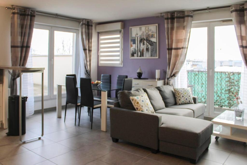 uma sala de estar com um sofá e uma mesa em Bright well-appointed nest near Stade de France em Saint-Denis