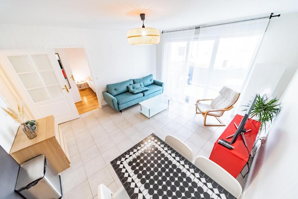 a living room with a couch and a chair at Charming T2 (44M2) bright with Terrace in Villeurbanne