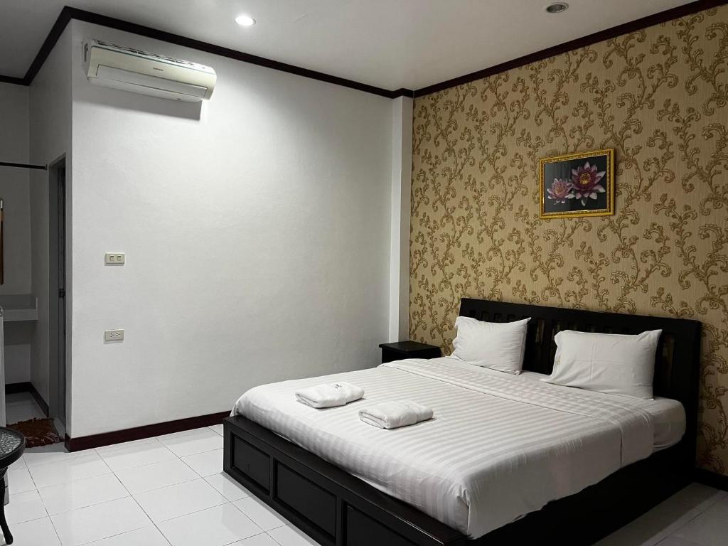 een slaapkamer met een bed met twee handdoeken erop bij บ้านบัวรีสอร์ท in Chiang Rai