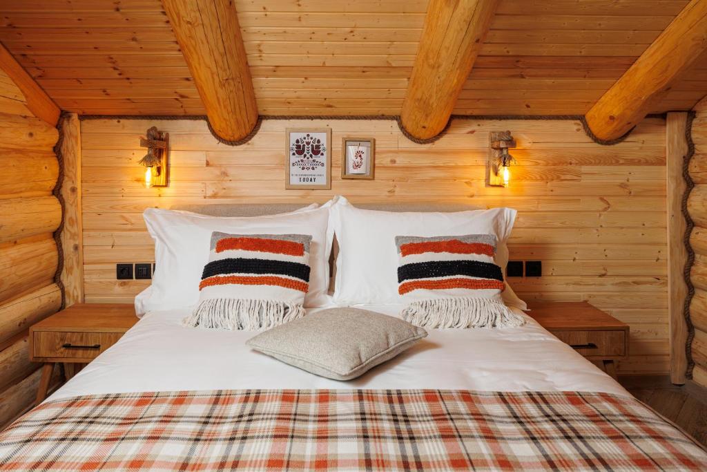 a bedroom with a bed in a log cabin at Chalet Rozmarin Predeal in Predeal