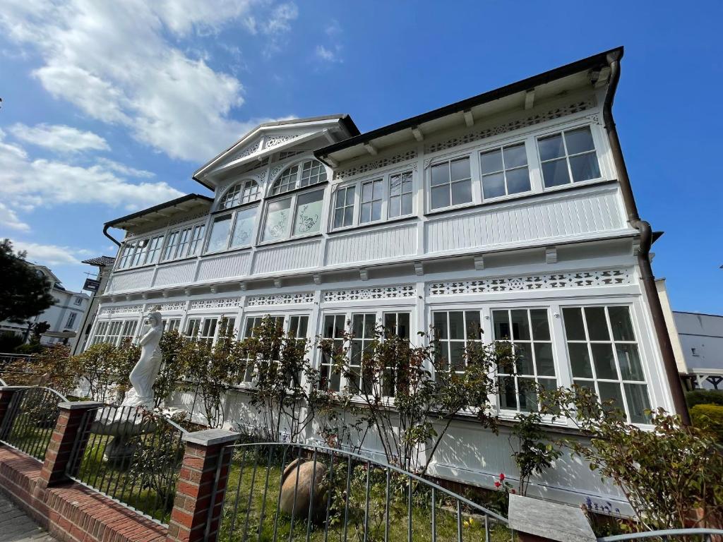 a white house with a fence in front of it at Villa Waldrose in Binz