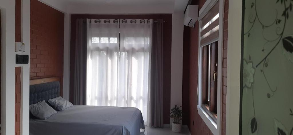 Schlafzimmer mit einem Bett und einem Fenster in der Unterkunft Southern villa in Wadduwa