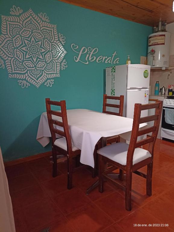 cocina con mesa, sillas y nevera en LIBERATA en Esquel