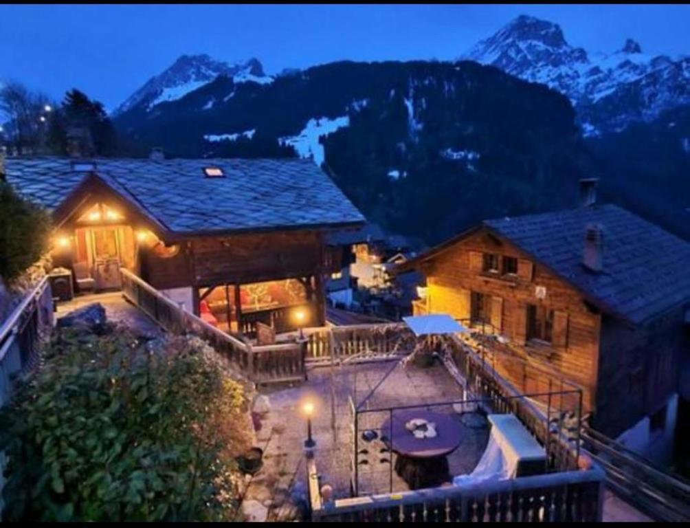 a log house with a patio and mountains in the background at Chalet Rayon de Soleil in Gryon