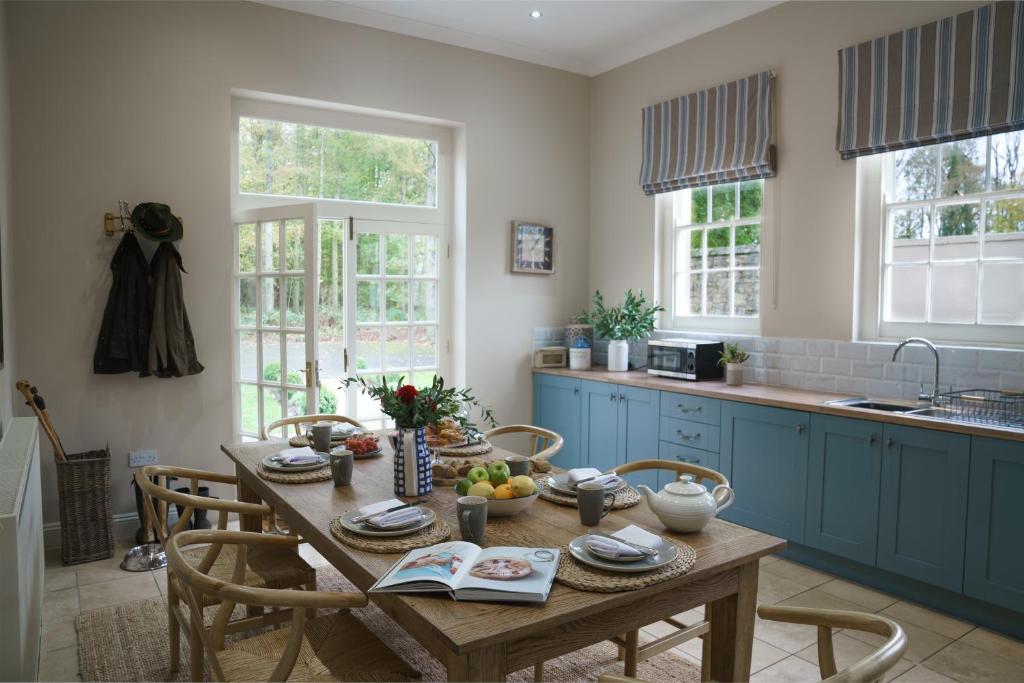 a kitchen with a wooden table with chairs and a table sidx sidx sidx at Dukeswood Cottage, Wynyard Hall in Grindon