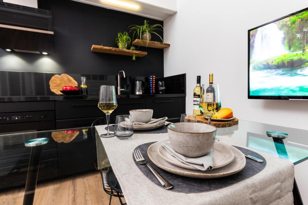 a kitchen with a table with plates and wine glasses at 2 Double floor Delft City Centre new family apartment in Delft