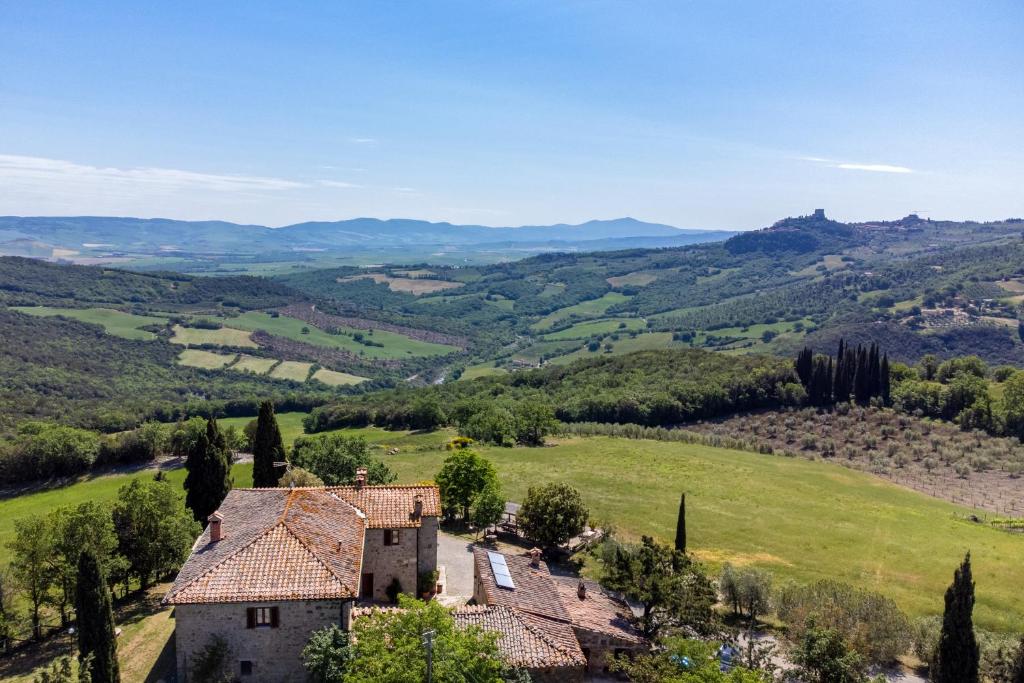 eine Luftansicht eines Bauernhauses auf einem grünen Feld in der Unterkunft Agriturismo Il Poderuccio in Castiglione dʼOrcia