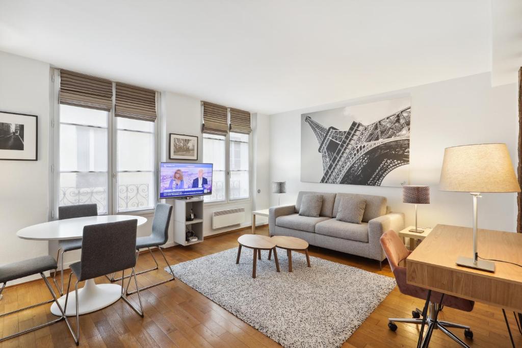 a living room with a couch and a table at Apartments for Work in City Center in Paris