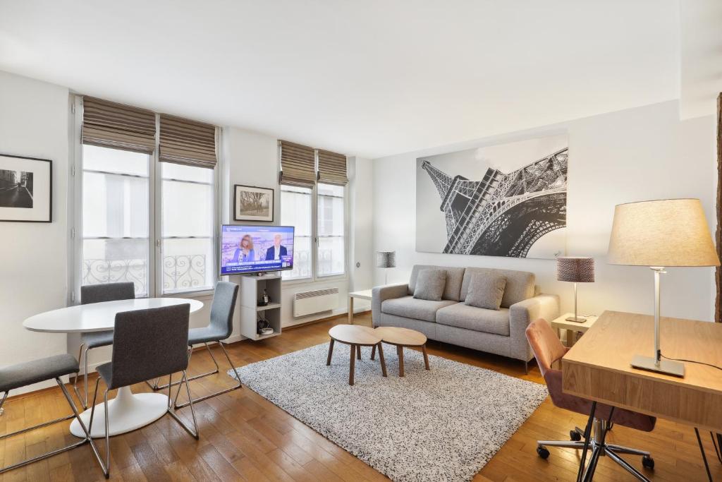 uma sala de estar com um sofá e uma mesa em Apartments for Work in City Center em Paris