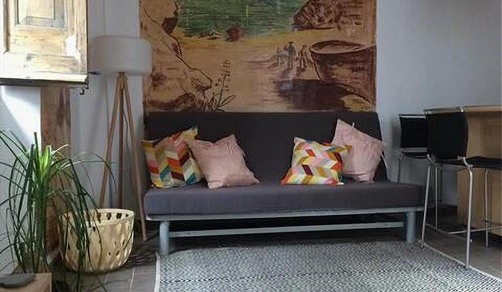 ein Sofa mit Kissen darauf im Wohnzimmer in der Unterkunft Apartamento de diseño cerca de tren, playa y BCN in Masnou