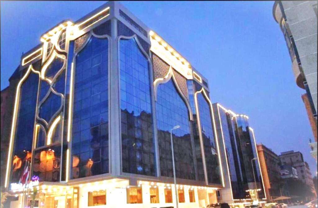 un grande edificio in vetro con luci sopra di QUIET Jeddah Al Hamra a Gedda