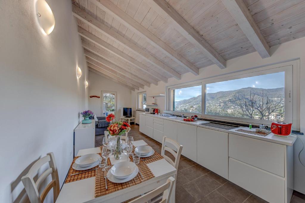 eine Küche und ein Esszimmer mit Tisch und Stühlen in der Unterkunft CASA PARADISO Vista di lusso e tranquillità nello stesso posto in Camogli