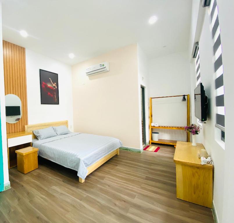 a bedroom with a bed and a tv in it at Moon's House Homestay Quy Nhơn in Quy Nhon