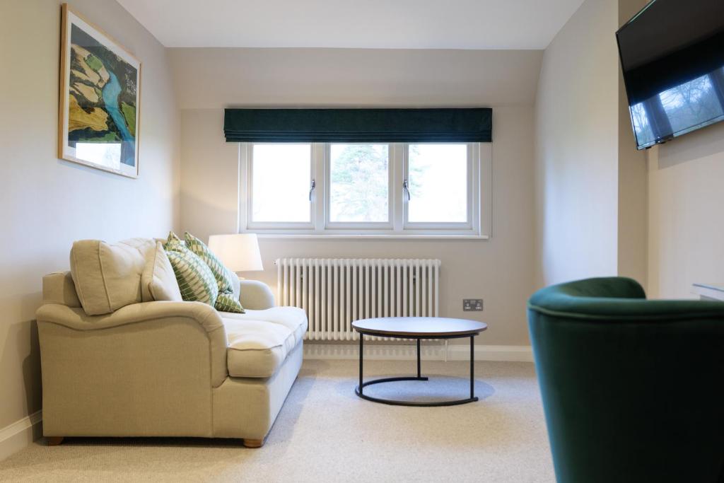 a living room with a couch and a table at The Olive Apartment - Greentrees Estate in Haywards Heath