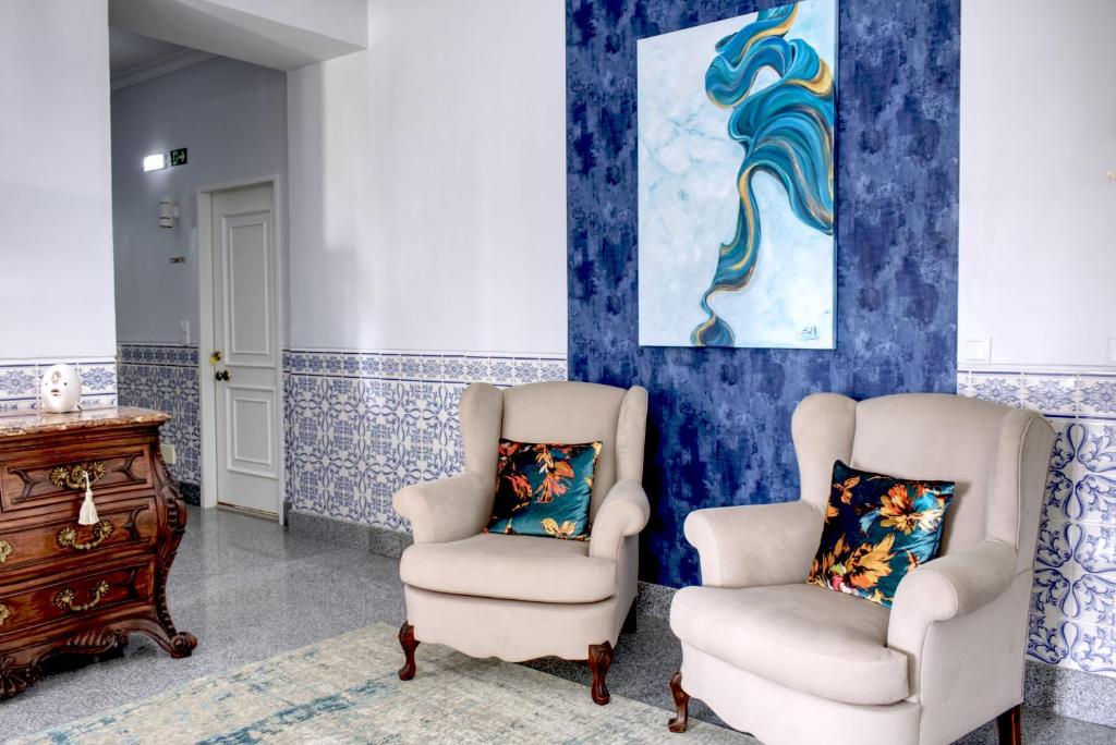 2 sillas y vestidor en una habitación con paredes azules en Palacete da Baixa by MY CHOICE en Faro