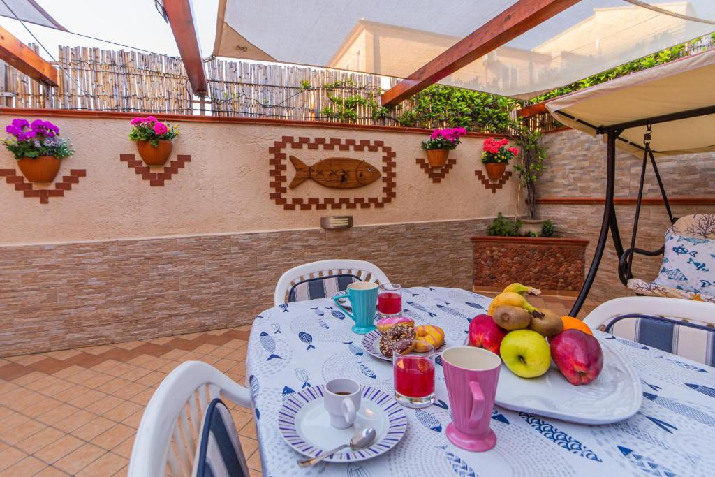 una mesa blanca con fruta en el patio en Casa Maria en La Maddalena