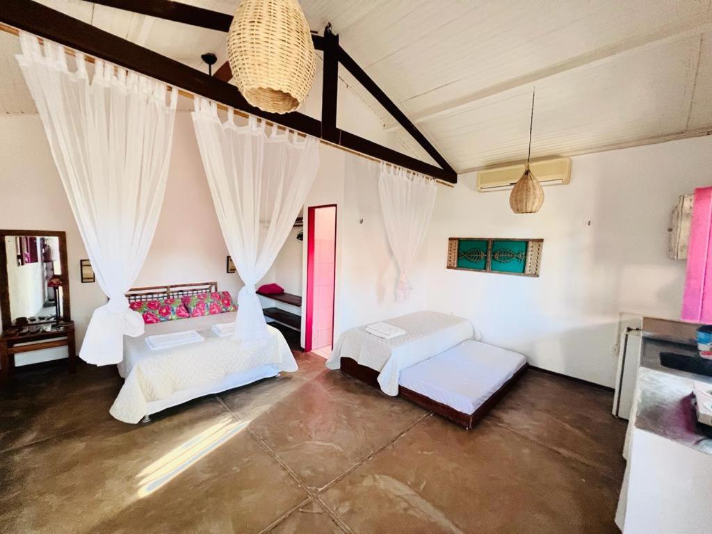a living room with two beds and a table at Gostoso Familly Chalés - Beira Mar in São Miguel do Gostoso