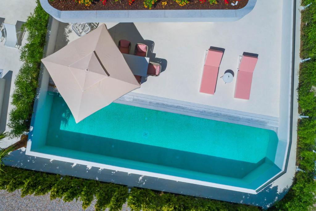 an overhead view of a pool with an umbrella at Cocoοns Suites & Villas Fourka in Fourka