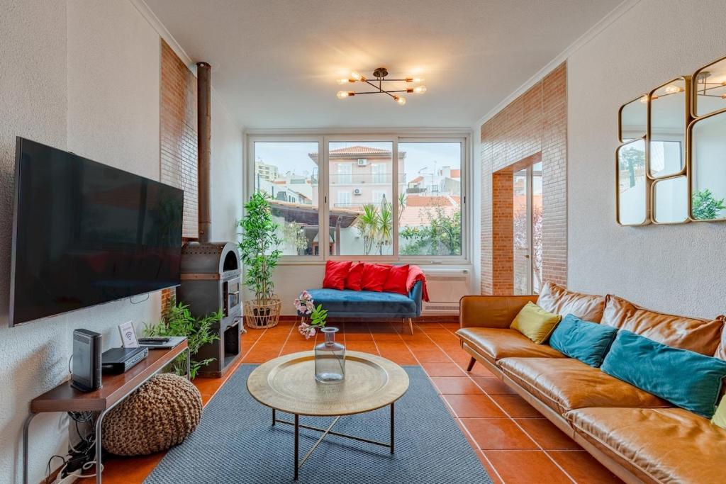 a living room with a couch and a tv at Setúbal Oasis House in Setúbal