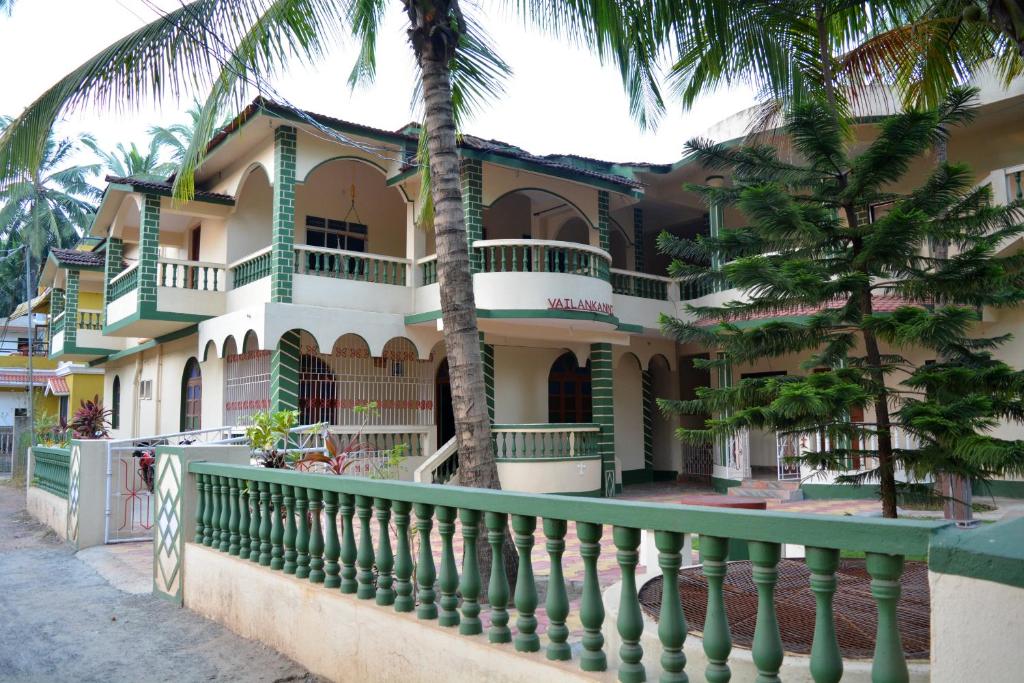 um edifício com palmeiras em frente em Vailankanni Guesthouse em Morjim
