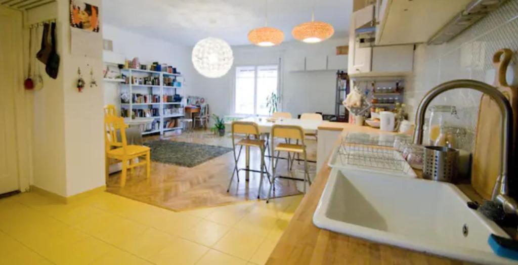 a kitchen with a sink and a counter with chairs at Radnoti Art Studio in Budapest