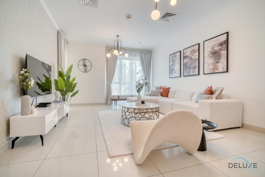 a white living room with a white couch and chairs at Harmonious 1BR at Al Shera Tower JLT by Deluxe Holiday Homes in Dubai