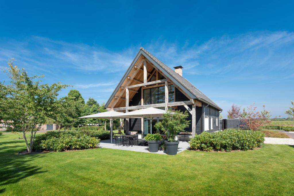 ein Fachwerkhaus mit Terrasse und Rasen in der Unterkunft Glundr! in Behelp
