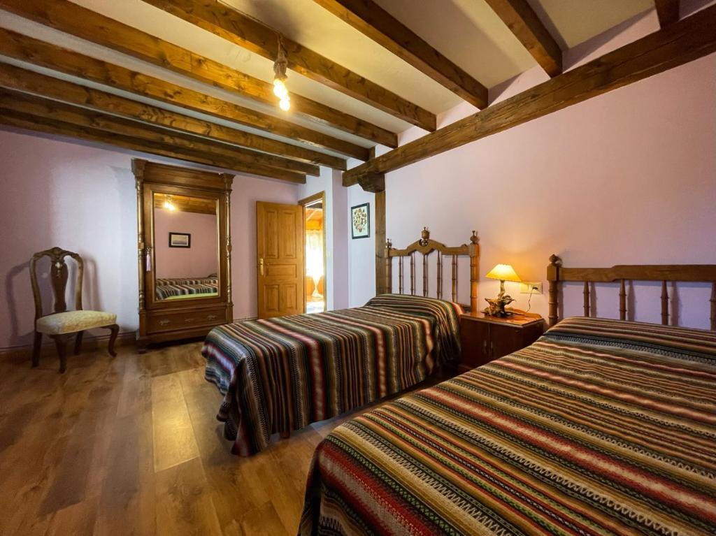 um quarto com 2 camas e um espelho em La Indefinida em Toranzo