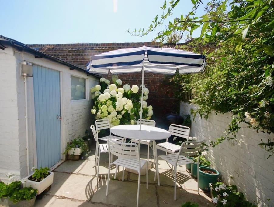 a table and chairs under an umbrella on a patio at Captains Cottage in Deal