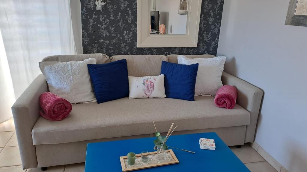 um sofá com almofadas e uma mesa numa sala de estar em Apartamento El Almendro em Puntagorda