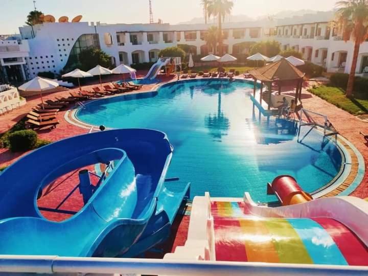 a large pool with a water slide in a resort at Uni sharm aqua park in Sharm El Sheikh