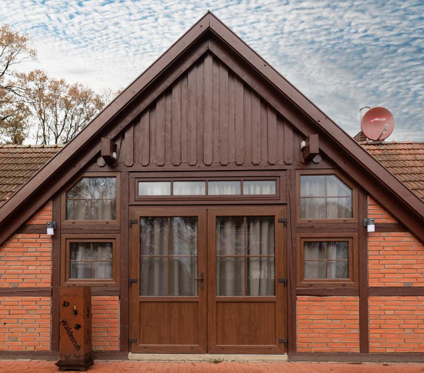 a house with a wooden garage with two windows at Monteurwohnung in Emstek