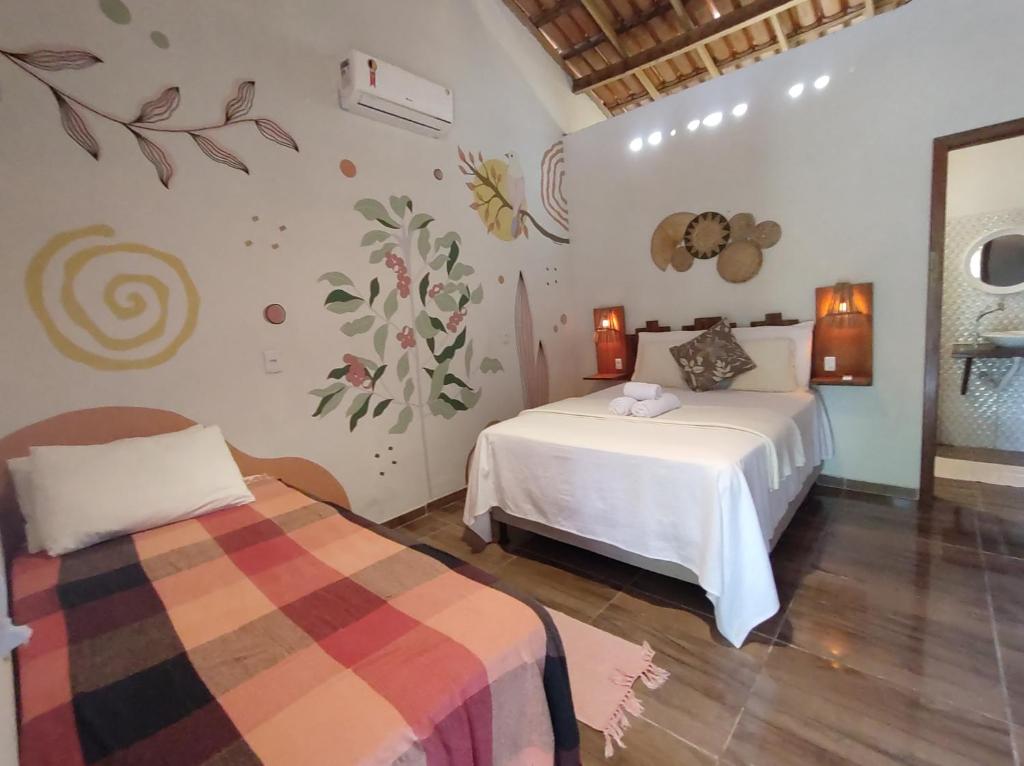 een slaapkamer met 2 bedden in een kamer bij Pousada Quintal dos Sonhos Xandó Caraiva in Caraíva
