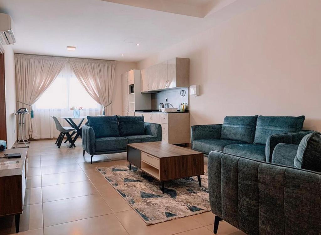ein Wohnzimmer mit 2 blauen Sofas und einem Tisch in der Unterkunft Luxurious Superior Room Space Available in Accra